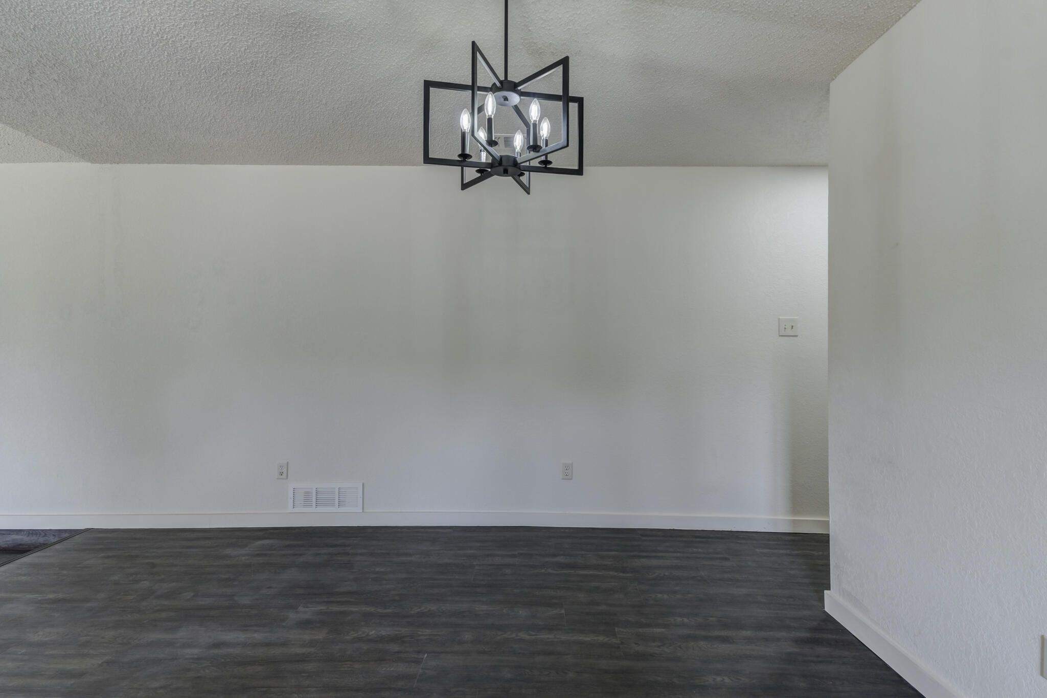 3006 93rd Street Lubbock, TX 79423 - Photo 22 of 35 a view of a small space with wooden floor and a chandelier