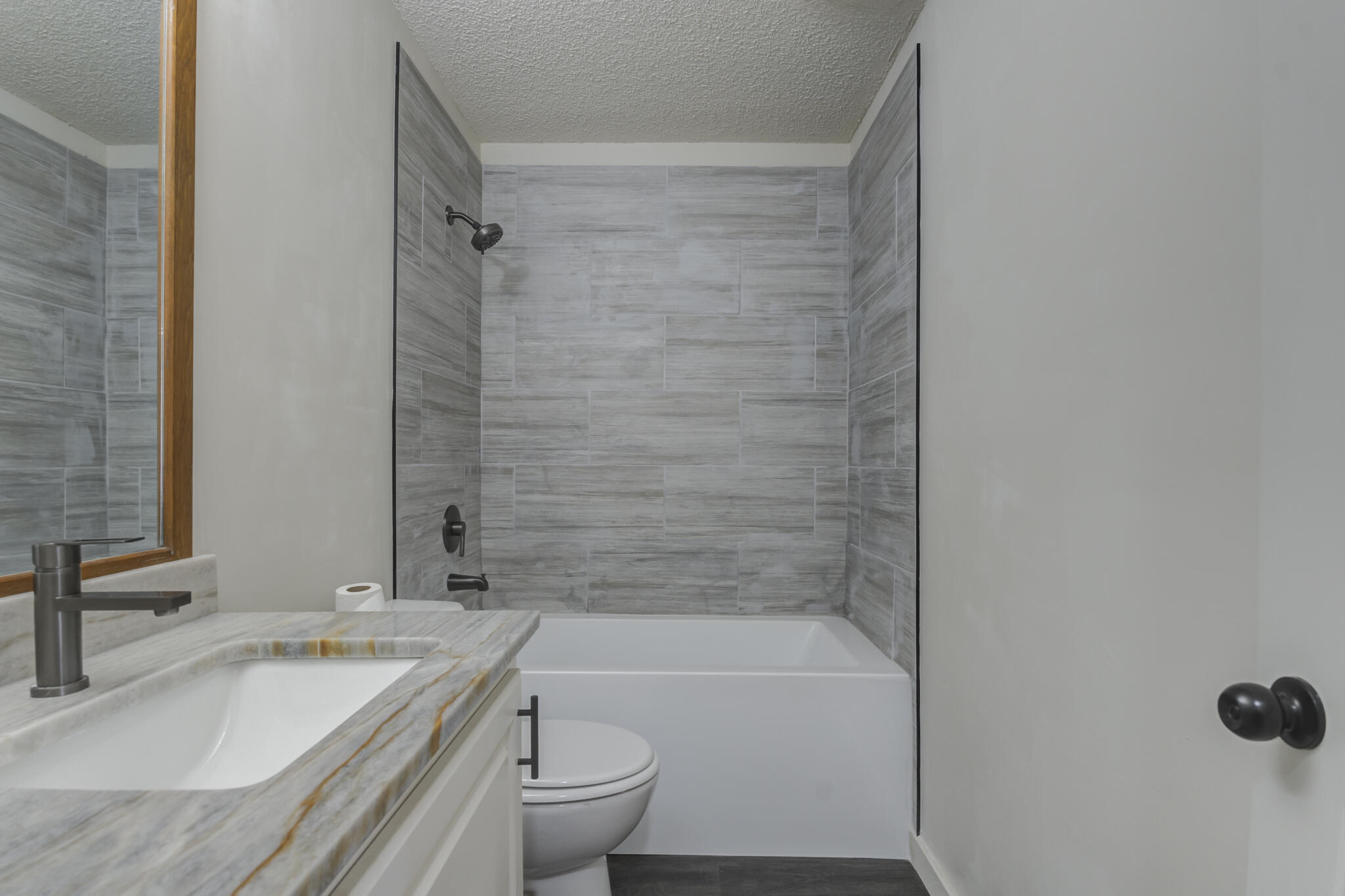 3006 93rd Street Lubbock, TX 79423 - Photo 23 of 35 a bathroom with a granite countertop bathtub shower sink vanity and toilet