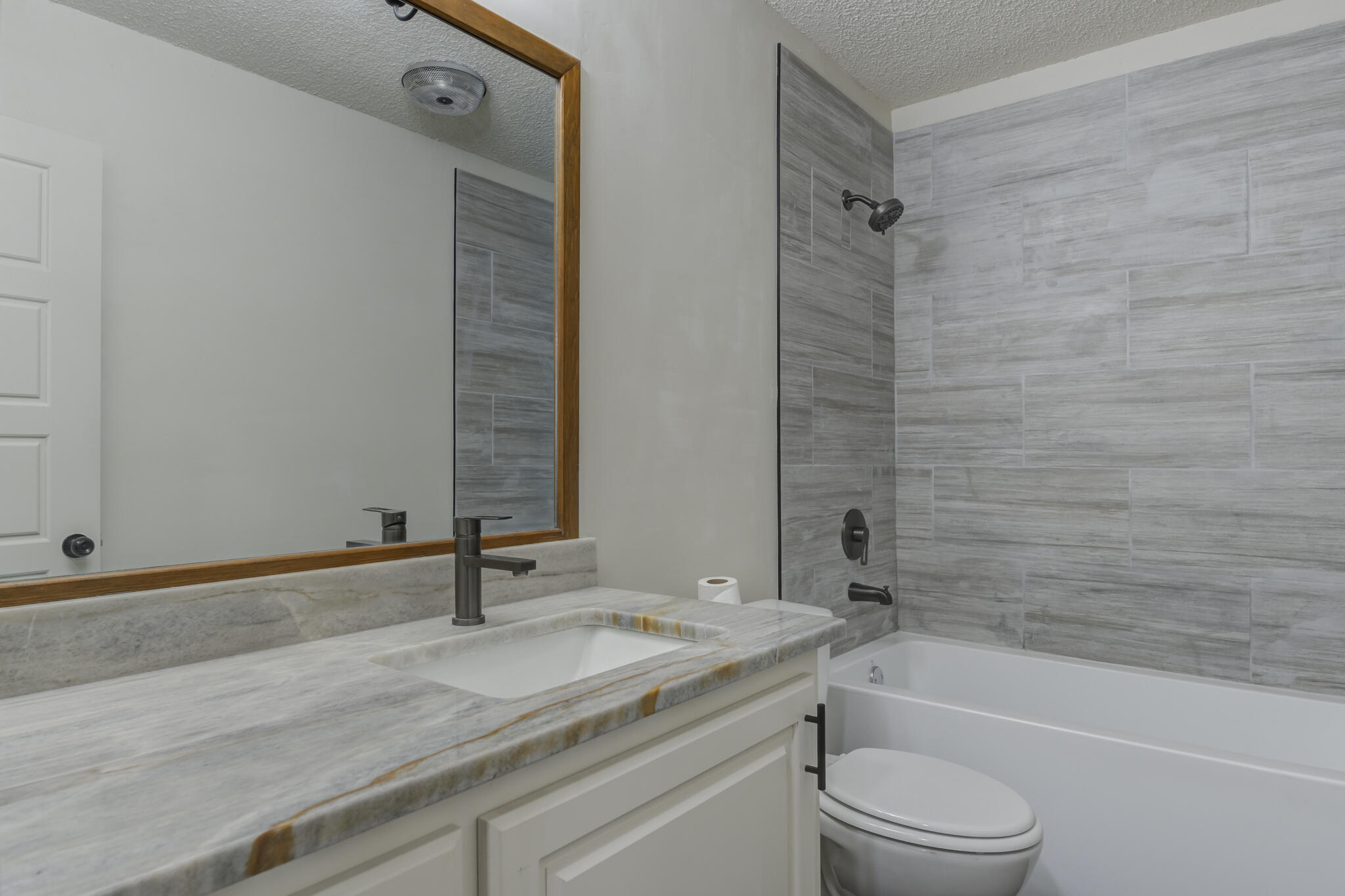 3006 93rd Street Lubbock, TX 79423 - Photo 24 of 35 a bathroom with a granite countertop sink a toilet and shower
