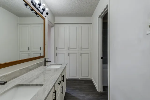 a bathroom with a granite countertop sink and a mirror