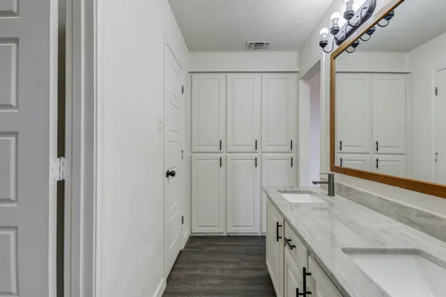 a bathroom with a granite countertop sink and a mirror