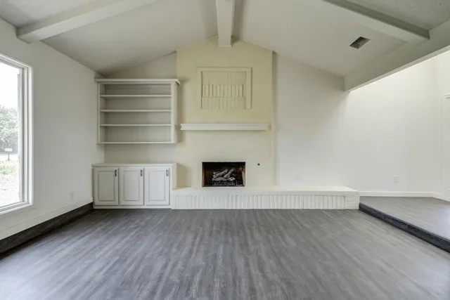a view of a room with wooden floors and fireplace