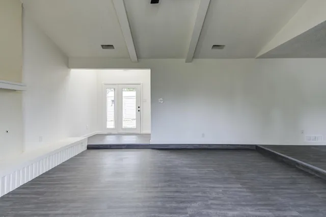 a view of wooden floor and windows in a room