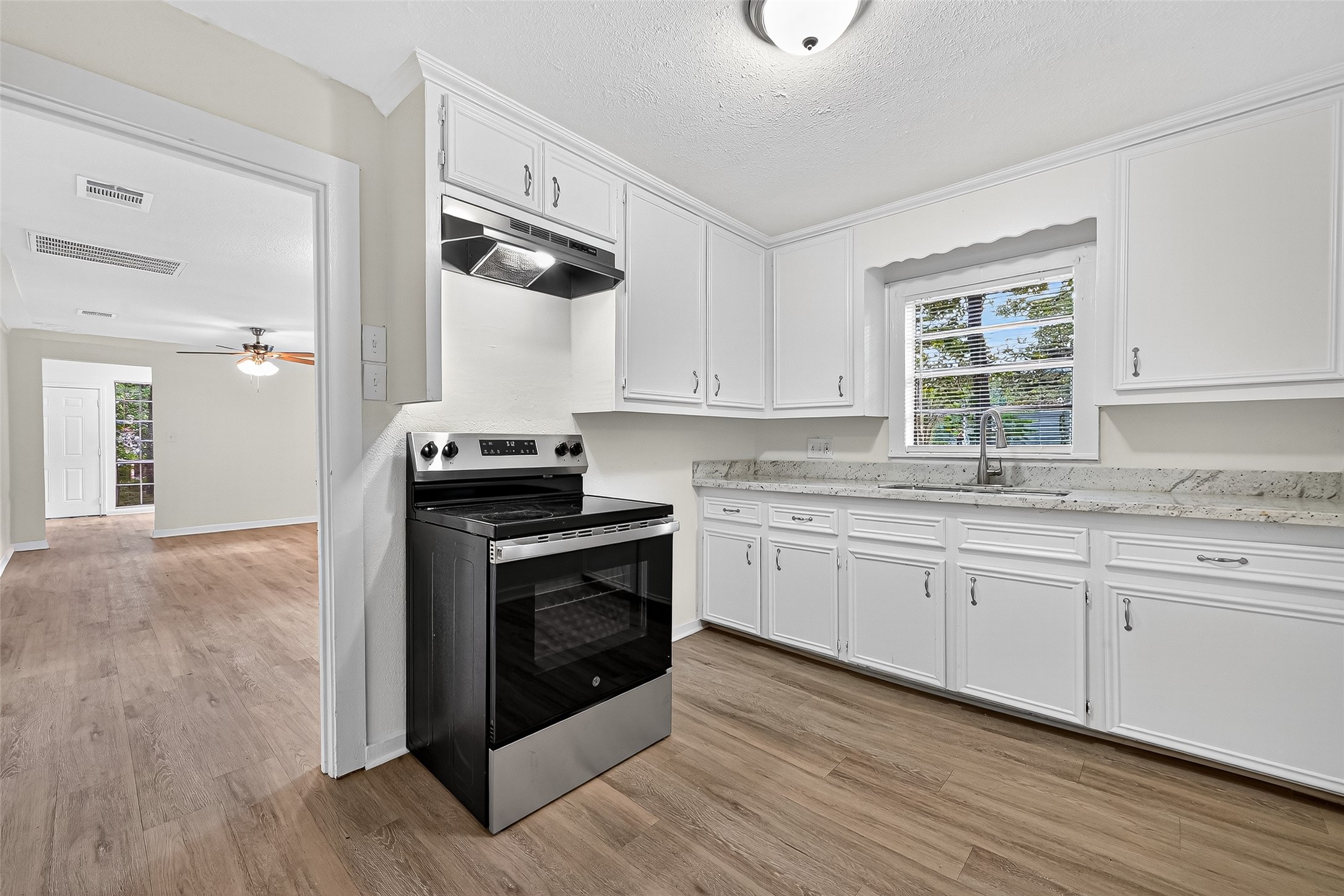 16643 Lake Circle Conroe, TX 77302 - Photo 19 of 47 a kitchen with granite countertop a stove a sink and a microwave