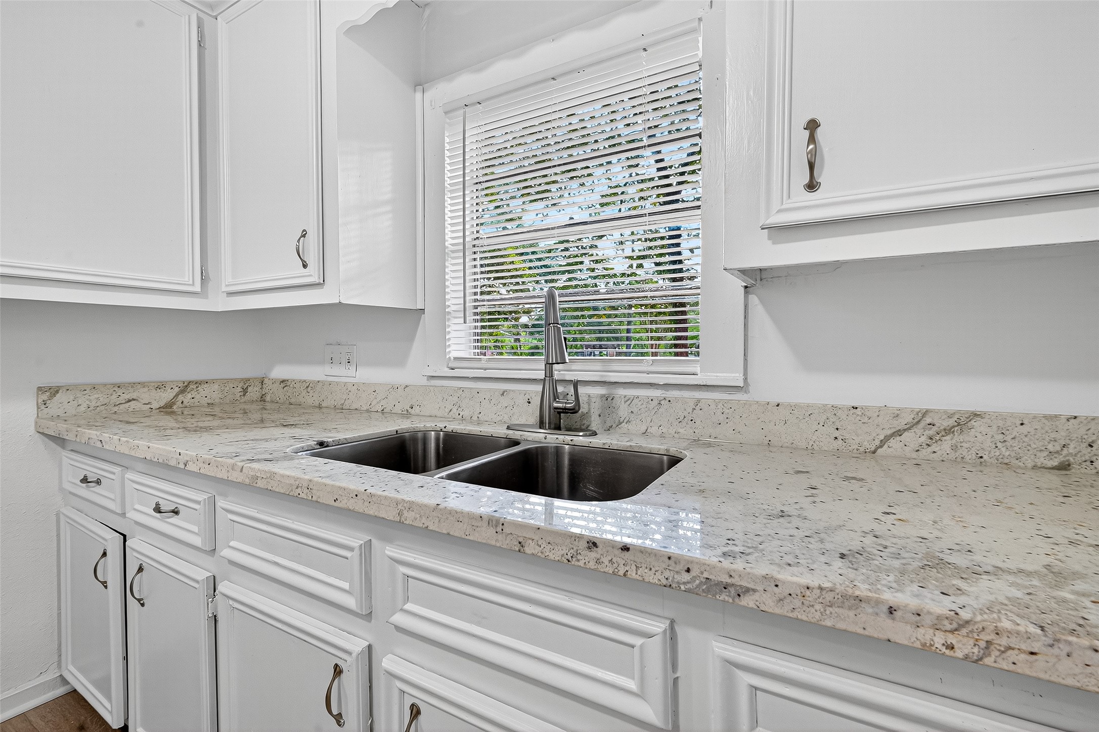 16643 Lake Circle Conroe, TX 77302 - Photo 21 of 47 a kitchen with granite countertop a sink and white cabinets