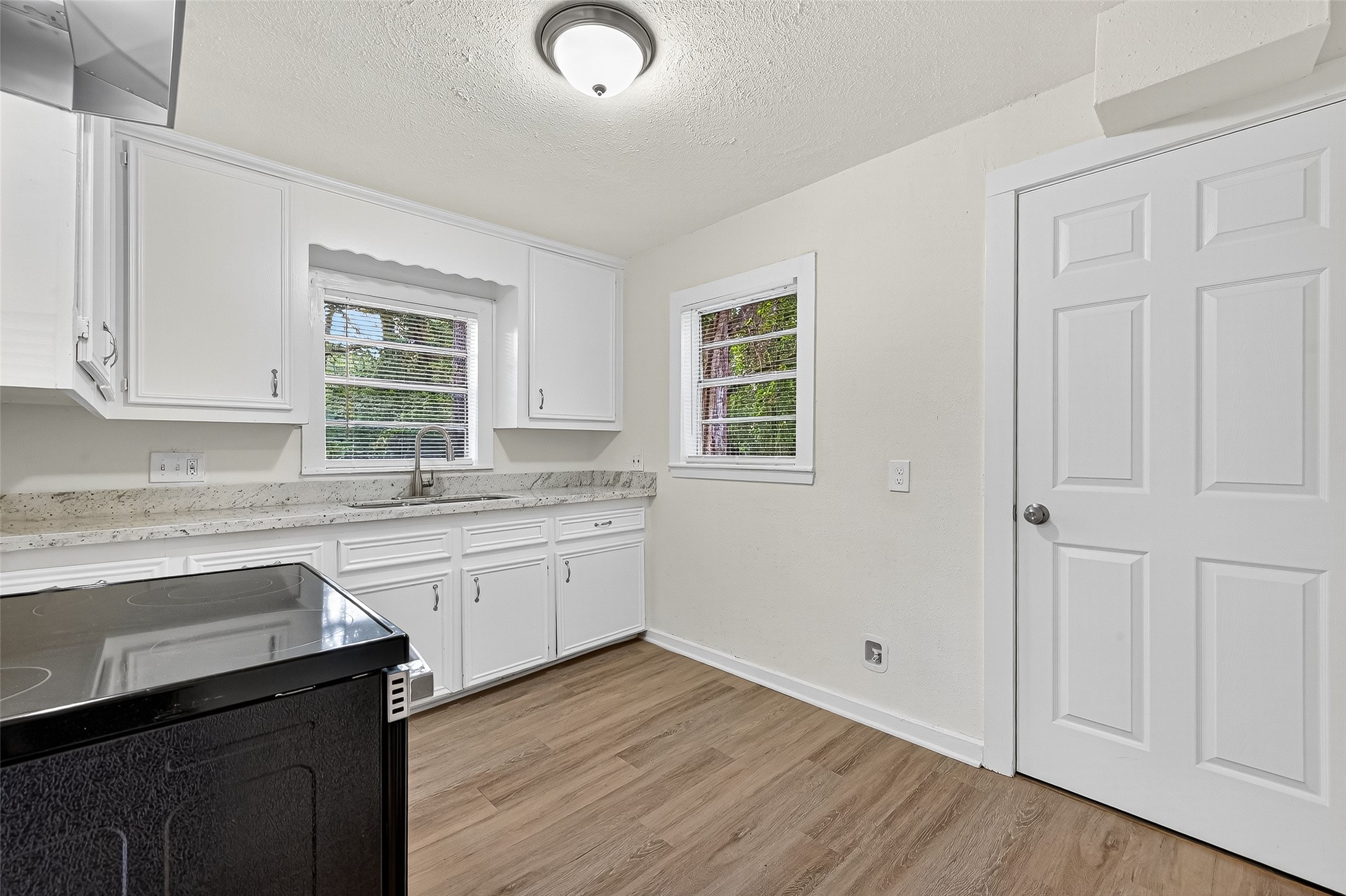 16643 Lake Circle Conroe, TX 77302 - Photo 24 of 47 a kitchen with granite countertop white cabinets and sink