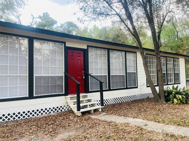 a view of a house with backyard and sitting area