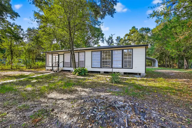 a view of a house with backyard and trees