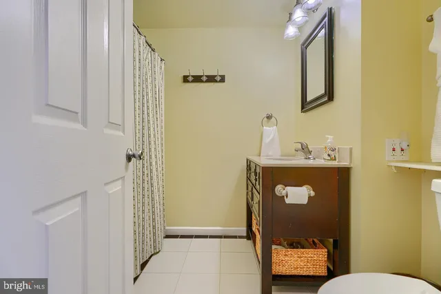 a bathroom with a toilet sink vanity and mirror