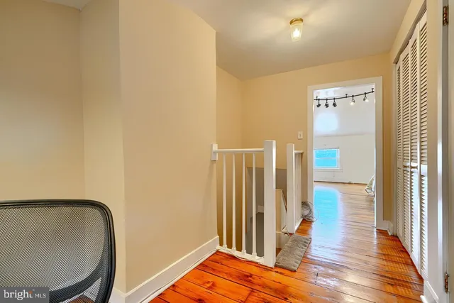 a view of a hallway with wooden floor and staircase
