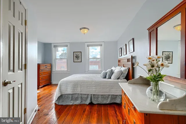 a bedroom with a bed and wooden floor