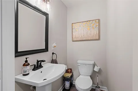 a bathroom with a toilet sink and mirror
