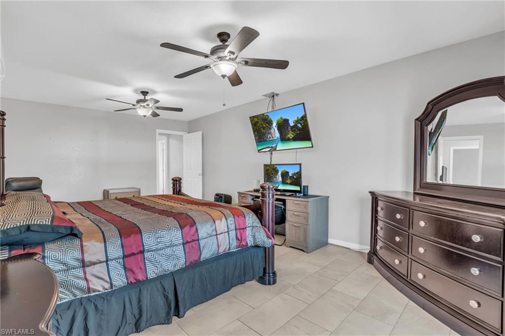 883 Coconut Circle East Naples, FL 34104 - Photo 15 of 32 a bedroom with a bed and a chandelier