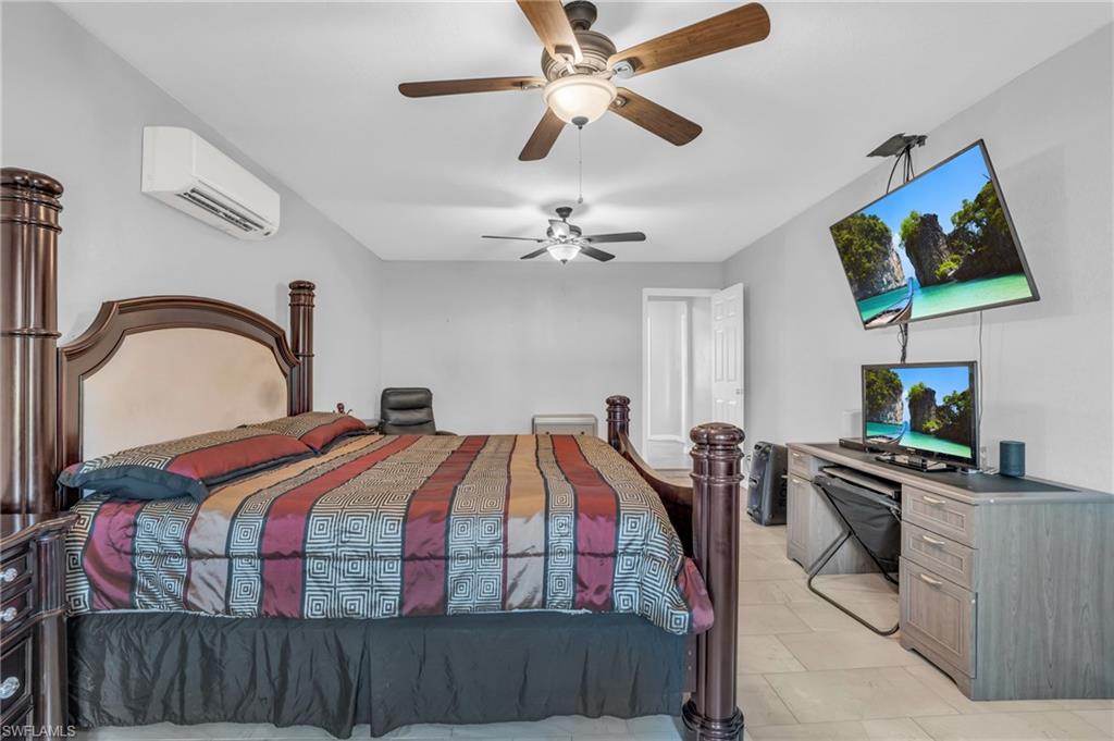 883 Coconut Circle East Naples, FL 34104 - Photo 16 of 32 a bedroom with a bed and a flat screen tv