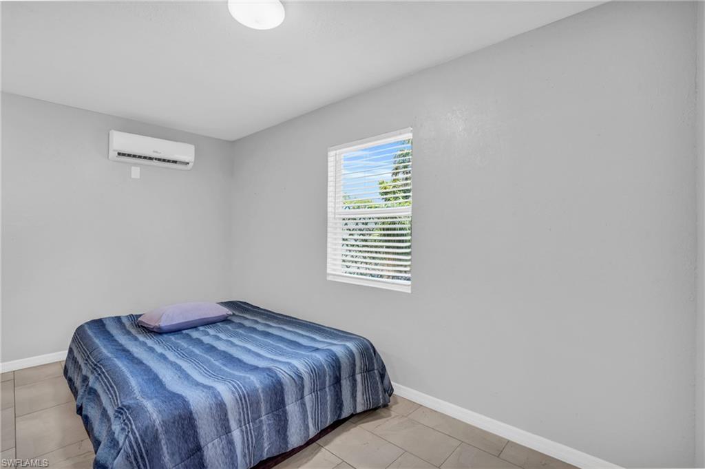 883 Coconut Circle East Naples, FL 34104 - Photo 18 of 32 a bedroom with a bed and a window