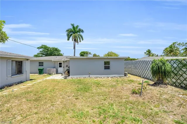 a view of backyard of house with wooden fence