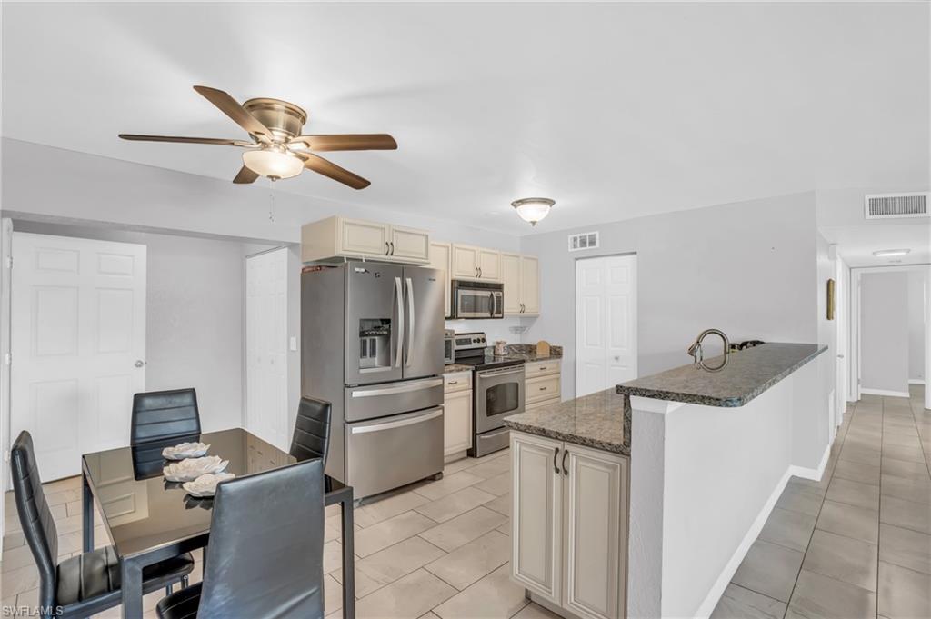 883 Coconut Circle East Naples, FL 34104 - Photo 6 of 32 a kitchen with refrigerator cabinets and furniture