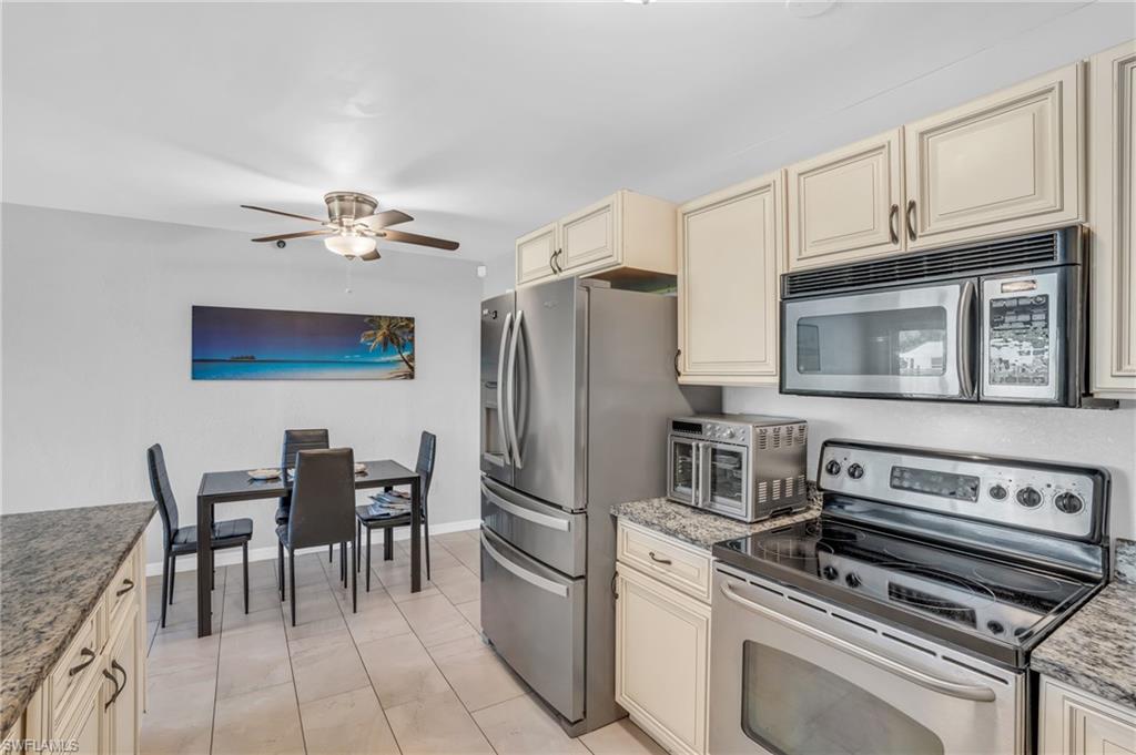883 Coconut Circle East Naples, FL 34104 - Photo 7 of 32 a kitchen with stainless steel appliances granite countertop a stove and a refrigerator