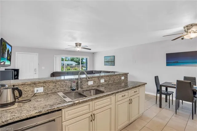 a kitchen with granite countertop a sink and white cabinets
