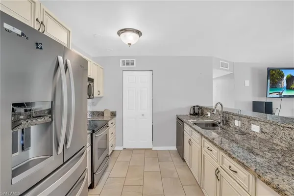 a kitchen with stainless steel appliances granite countertop a refrigerator and a sink