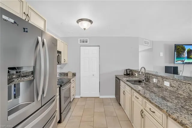 a kitchen with stainless steel appliances granite countertop a refrigerator and a sink