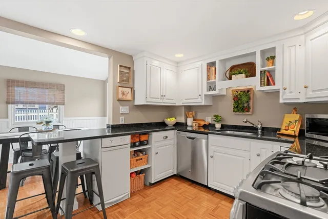 a kitchen with stainless steel appliances granite countertop a stove and white cabinets