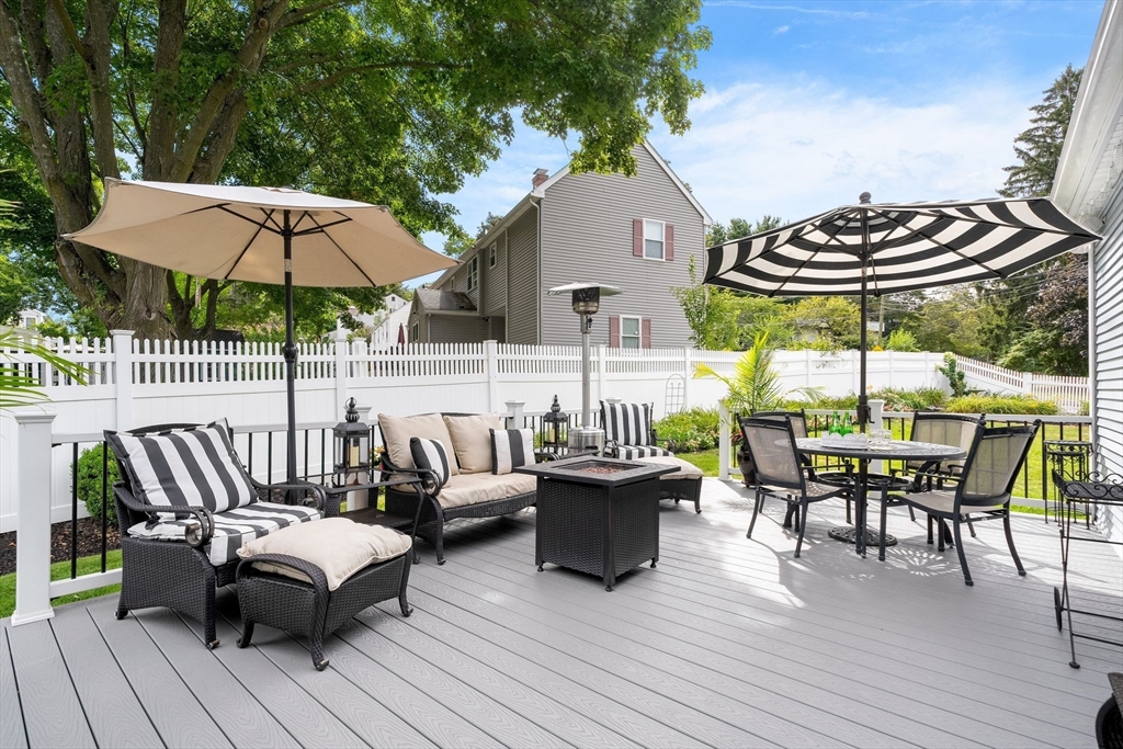 4 Joyce Road Arlington, MA 02474 - Photo 34 of 42 a roof deck with table and chairs under an umbrella with wooden floor