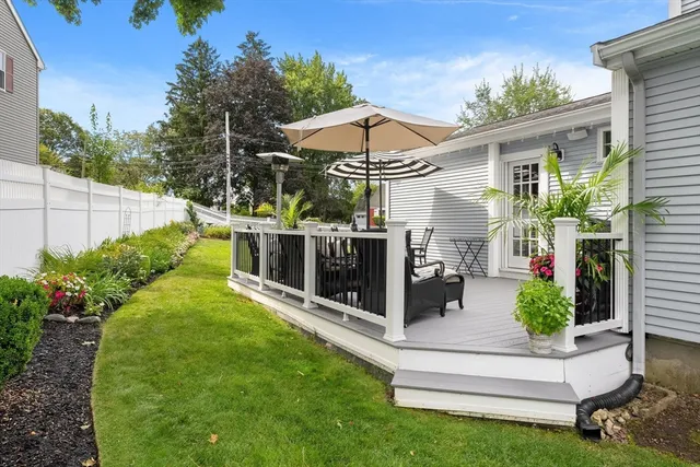a view of a chair and table in backyard of the house