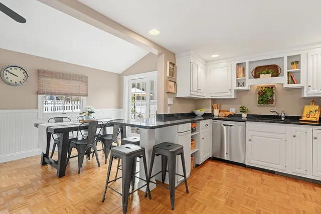 a kitchen with stainless steel appliances granite countertop a table and chairs in it