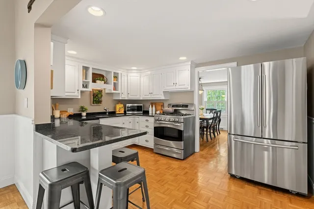 a kitchen with kitchen island a counter top space cabinets stainless steel appliances and a window