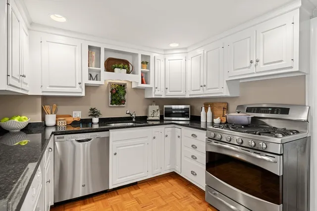 a kitchen with granite countertop white cabinets and appliances