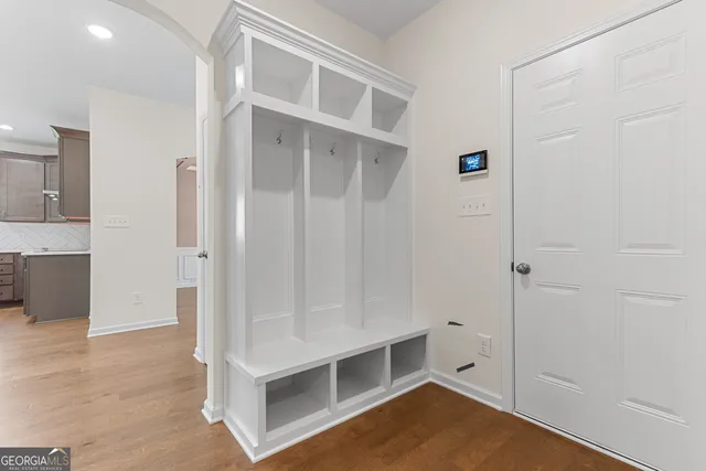 an empty room with wooden floor a ceiling fan and a fireplace