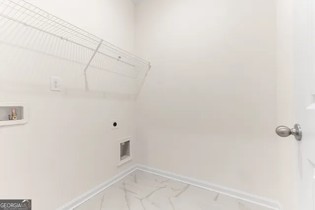 an empty room with wooden floor and a kitchen space