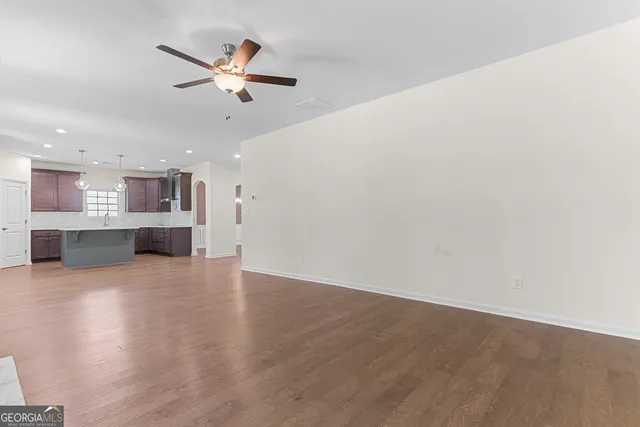 a large kitchen with granite countertop a large center island a sink stainless steel appliances and cabinets