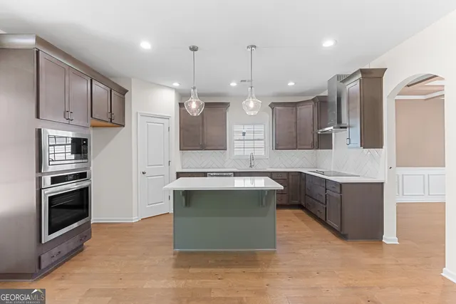 a kitchen with kitchen island a sink stainless steel appliances and cabinets