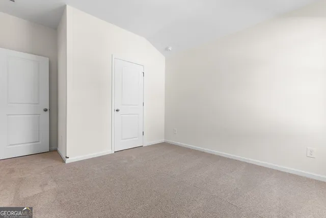 a front view of a house with a big yard and large trees