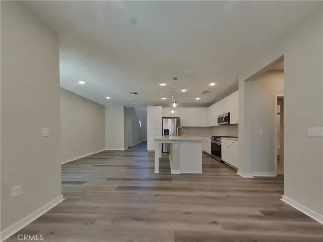 a view of kitchen with kitchen island white cabinets and stainless steel appliances