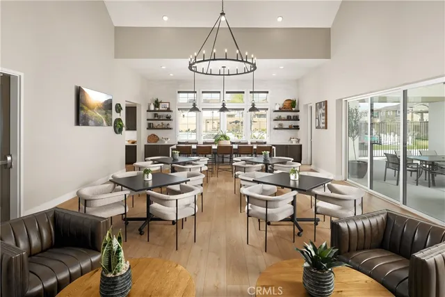 a living room with couches a fireplace and kitchen view with wooden floor