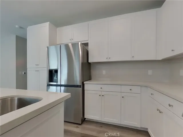 a kitchen with stainless steel appliances white cabinets and a refrigerator