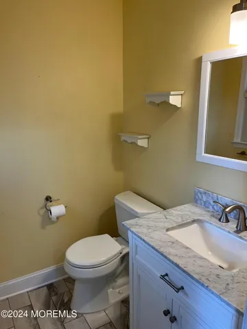 a bathroom with a granite countertop toilet and a sink