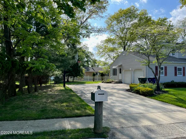 a front view of a house with a yard and tree