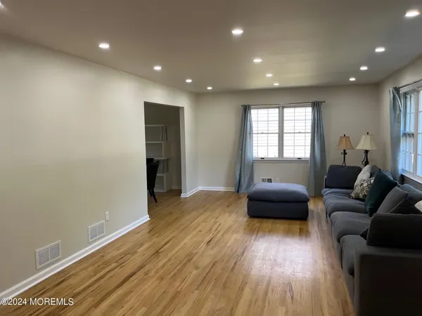 a living room with furniture and a wooden floor
