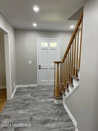 a view of a hallway with wooden floor and staircase