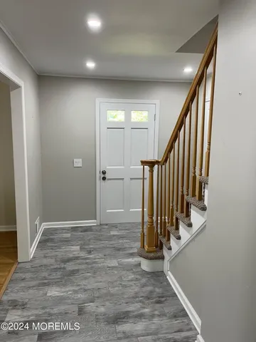 a view of a hallway with wooden floor and staircase