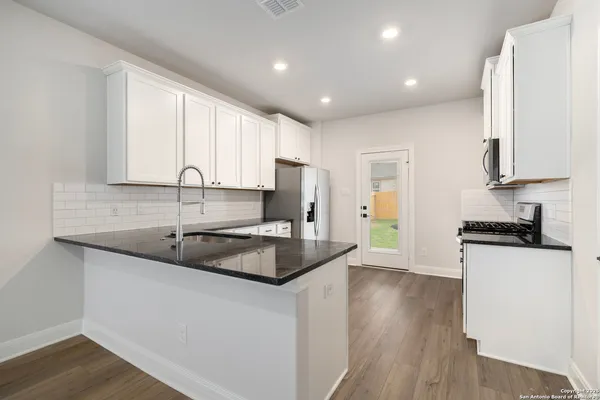 a kitchen with a sink stove and cabinets