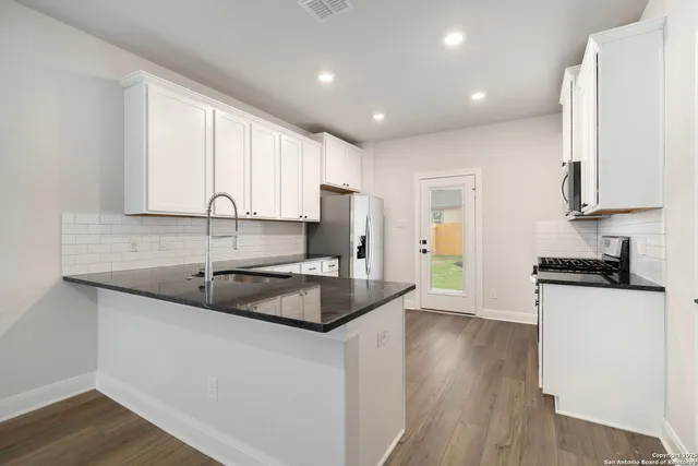 a kitchen with a sink stove and cabinets