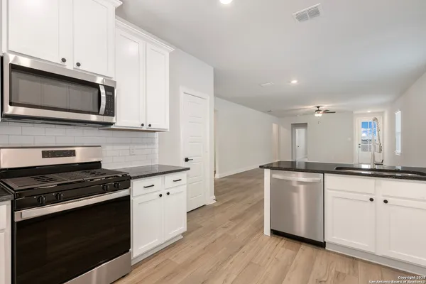 a kitchen with stainless steel appliances a stove microwave and sink