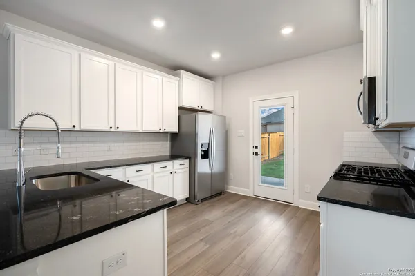 a kitchen with a sink a refrigerator a stove a microwave and cabinets