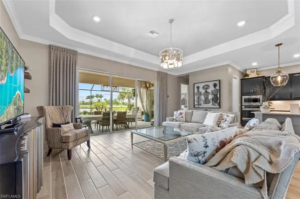 a living room with furniture chandelier and a flat screen tv