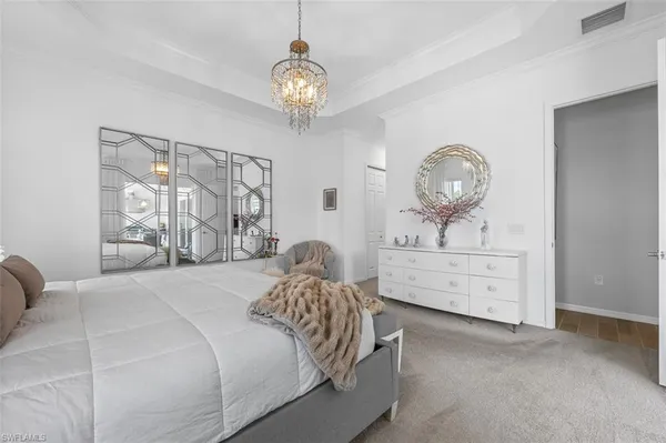 a bedroom with a bed and a chandelier